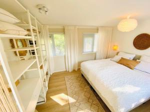 a bedroom with a white bed and shelves at Trendy House Hattem nr64 in Hattemerbroek