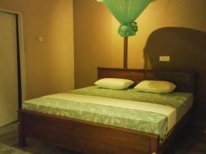 Un dormitorio con una cama con dos almohadas encima. en Villa U-Soori, en Hikkaduwa
