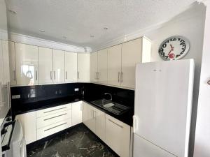 a kitchen with a white refrigerator and a clock at Luxury Apt. with Stunning Sea View in Acantilado de los Gigantes