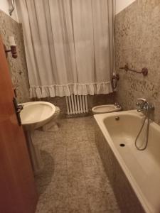 een badkamer met een wastafel, een bad en een toilet bij B&B villa Sofia in Montecosaro