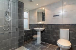 a bathroom with a toilet and a sink and a shower at Spacious 5-Bedroom Townhouse in the West-End in Aberdeen