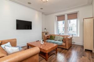 a living room with two couches and a coffee table at Spacious 5-Bedroom Townhouse in the West-End in Aberdeen