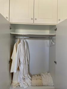 a closet with white cabinets and white towels at Olive House Apartment Paros in Kampos Paros