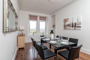 a dining room with a black table and black chairs at Spacious 5-Bedroom Townhouse in the West-End in Aberdeen
