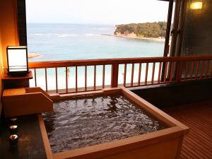 a room with a view of the ocean from a balcony at Hotel Sanrakuso in Shirahama