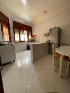 a large kitchen with a refrigerator and a table at Mehdia Ville in Plage de Mehdia