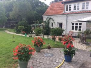 un patio de ladrillo con flores frente a una casa en Aabels, en Saeby