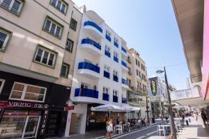 un edificio con balcones azules en una calle de la ciudad en MUNDOBOOKING Centro Levante, en Benidorm