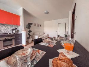 una cocina con una mesa con pan y vasos. en Appartamento Incantevole a 100metri dal mare e vicino a pista ciclabile, en Imperia