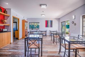 a restaurant with tables and chairs in a room at Buganvilias Do Meco Guest house in Sesimbra