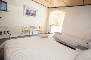Corio Bay Motel في Corio: غرفة نوم بسريرين وطاولة وكراسي