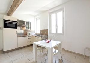 biała kuchnia z białym stołem w pokoju w obiekcie Studio Eco-Friendly Commandant André w Cannes