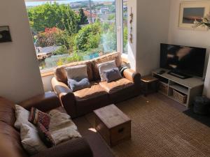 sala de estar con sofá y ventana grande en Sunnyview 5-Bed House in Kingsbridge with parking en Kingsbridge