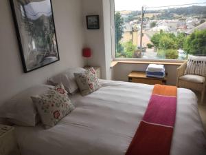 1 cama en un dormitorio con ventana grande en Sunnyview 5-Bed House in Kingsbridge with parking en Kingsbridge