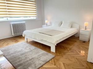 une chambre blanche avec un lit blanc et une fenêtre dans l'établissement The Blue Velvet Apartment, à Belgrade