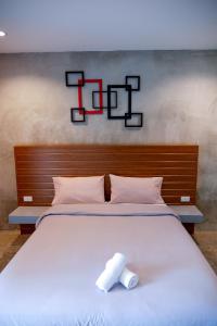 uma grande cama branca com uma toalha em B3 Hotel em Nakhon Si Thammarat