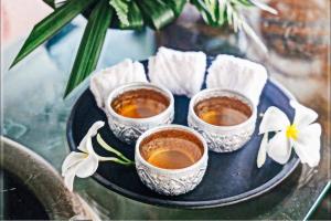 a tray with four cups of coffee on a table at The Old Phuket - Karon Beach Resort - SHA Plus in Karon Beach