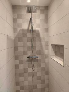 une douche dans une salle de bain avec un mur carrelé dans l'établissement Apartment auf der Schladminger Sonnenseite - smart, zentral & ruhig, à Schladming 30 autres photos