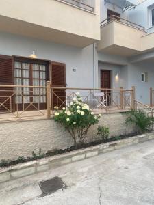 a house with a balcony and a plant with white flowers at Kalloni Luxury Apartment in Volos