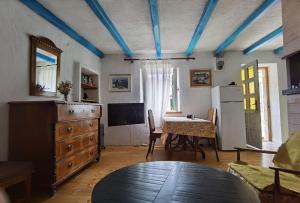 Habitación con mesa y cocina con vigas azules. en Apartment Dalmatera, en Rogoznica