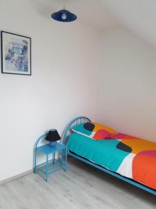 un dormitorio con una cama y una mesa en Le Plaisance, en Ourville-en-Caux