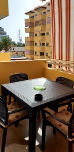 einen schwarzen Tisch und Stühle auf dem Balkon in der Unterkunft Luminoso y bonito apartamento con piscina en frente del mar in Los Cristianos