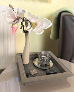 einen Tisch mit einer Vase mit Blumen und Steinen darauf in der Unterkunft Haus Hotel & Pension am Birnengarten in Magdeburg