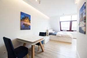 a white room with a desk and a bedroom at Happy Apartments - Just In Center in Wrocław
