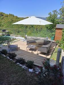斯波萊托的住宿－Alloggio turistico Montelirossi，木甲板配有桌子和遮阳伞