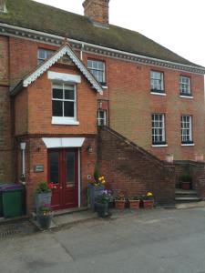 a red brick house with potted plants in front of it at Stunning 1 bedroom self contained apartment in Kent