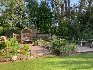 un jardín con un banco en medio de un patio en Fir Tree Lodge, en Blairgowrie