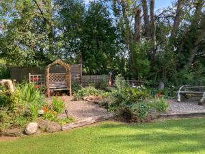 a garden with a bench in the middle of a yard at Fir Tree Lodge in Blairgowrie