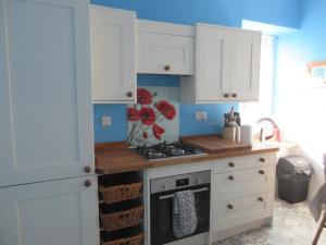 a kitchen with white cabinets and a stove at Anchor House in Pittenweem