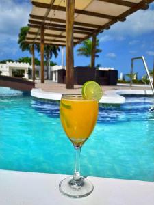 a drink sitting on a table next to a swimming pool at Hotel Castillo del Mar in Ríohacha