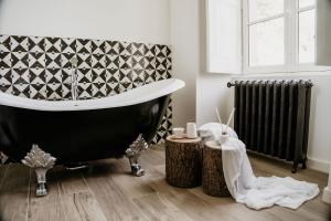 a bathroom with a black and white tub and a radiator at Domaine de La Mazure in La Chapelle-Basse-Mer