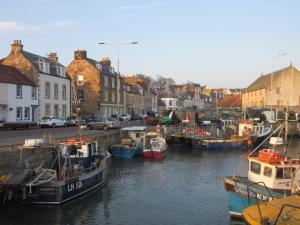 a group of boats are docked in a harbor at Anchor House in Pittenweem