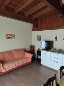 a living room with a couch and a flat screen tv at Villa Tenuta ...un oasi di pace in Puntalazzo
