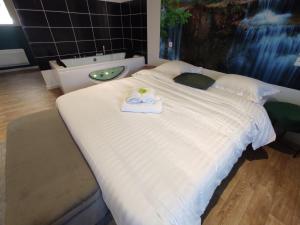 een slaapkamer met een groot wit bed en een wastafel bij NG SuiteHome - Lille I Roubaix Centre I Coq Français - Balnéo - Netflix - Wifi in Roubaix