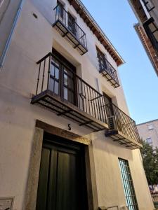 um edifício branco com varandas e uma porta em Apartamentos Garam em Granada