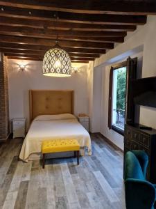 um quarto com uma cama grande e um banco amarelo em Apartamentos Garam em Granada