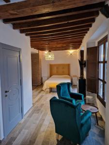 um quarto com uma cama e duas cadeiras num quarto em Apartamentos Garam em Granada