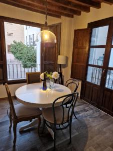 una sala da pranzo con tavolo e sedie bianchi di Casa Garam a Granada Altre 11 foto