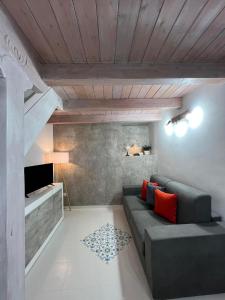 uma sala de estar com um sofá e uma televisão em La Sterlizia Green&Orange em Noto