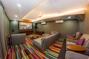 a waiting room with couches and a flat screen tv at The City Condos Playa del Carmen in Playa del Carmen