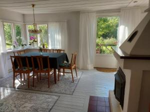 uma sala de jantar com mesa, cadeiras e janelas em Stuga i Ekestad em Kristianstad