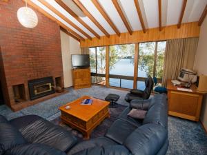 a living room with a couch and a fireplace at Derwent Retreat in Austins Ferry