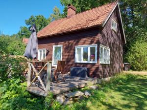 uma pequena casa com uma mesa e um guarda-chuva em Stuga i Ekestad em Kristianstad