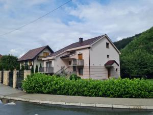 a white house next to a body of water at Apartmani Minjević in Bijelo Polje