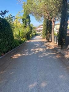 una strada vuota con alberi e edifici sui lati di La Casa di Mimì a Foligno