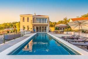 a swimming pool in front of a house at Villa SALVIA - new, modern villa near Split in Dugopolje